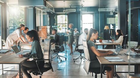 In einem Großraumbüro arbeiten die Mitarbeiter an ihren Schreibtischen