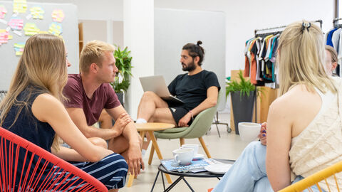 CoCreation-Ideenworkshop Eine Gruppe von Menschen sitzt in einem Stuhlkreis und redet miteinander